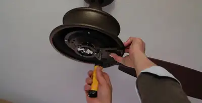 Electrician installing ceiling fan mounting bracket and fixture in Redding, CA