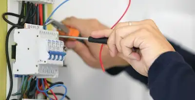 Electrician installing and adjusting circuit breakers in an electrical panel in Redding, CA