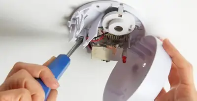 Certified technician wiring smoke detector during installation in Redding, CA